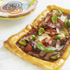 Roasted Vegetable & Sun-Dried Tomato Pesto Tart with basil leaves