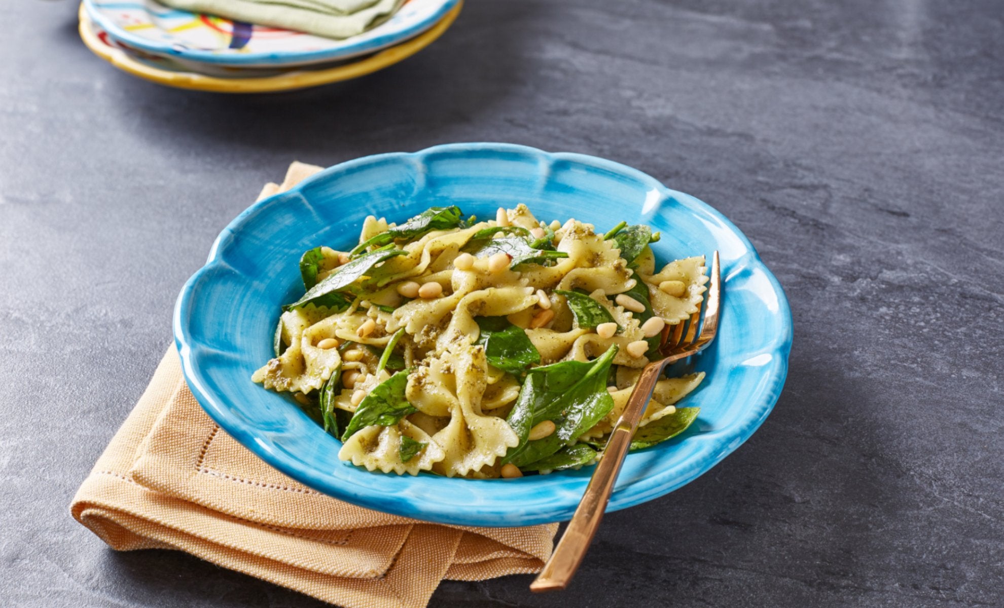 bowl of vegan pesto pasta with spinach and pine nuts by Sacla'