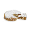 Panforte Cake dusted with icing sugar and with a slice of cake showing chunks of citrus peel and creamy white nuts.